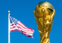 Official FIFA World Cup trophy with American flag behind it