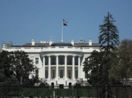 The image shows the White House in Washington, D.C., viewed from the South Lawn