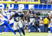 Jerry Jones faces retirement calls after Dallas Cowboys lose 28 to 20 Dallas Cowboys player in navy jumps to catch a pass as Rams defenders converge, ball in midair near the goal line