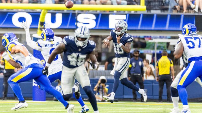 Shutterstock, Dallas Cowboys, Ringo Chiu, 2664070759 Dallas Cowboys player in navy jumps to catch a pass as Rams defenders converge, ball in midair near the goal line