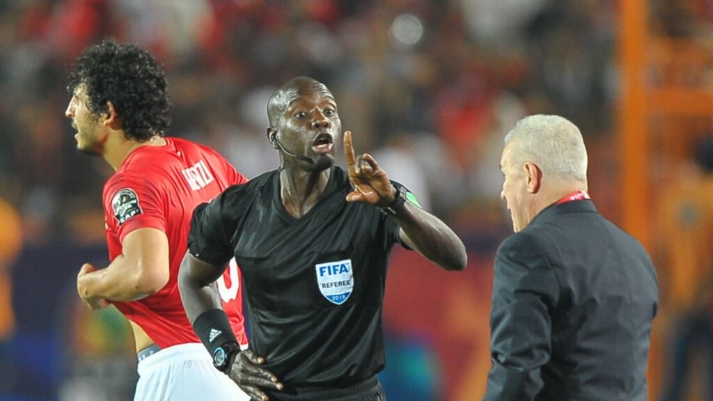 A discussion between the 4th referee and Egypt coach Javier Aguirre during the first group match.
