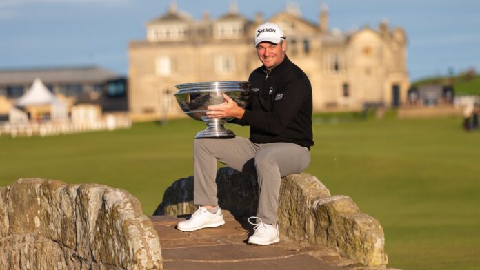 Ryan Fox celebrates winning the 2022 Alfred Dunhill Links Championship while holding the trophy on the iconic Swilcan Bridge at St Andrews.