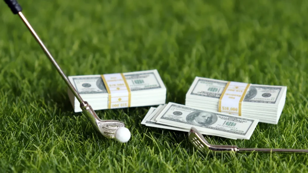 A bundle of bills and golf equipment on the green.