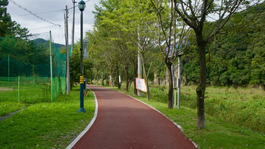 a red cycling path curves through seonbawi park in uljugun