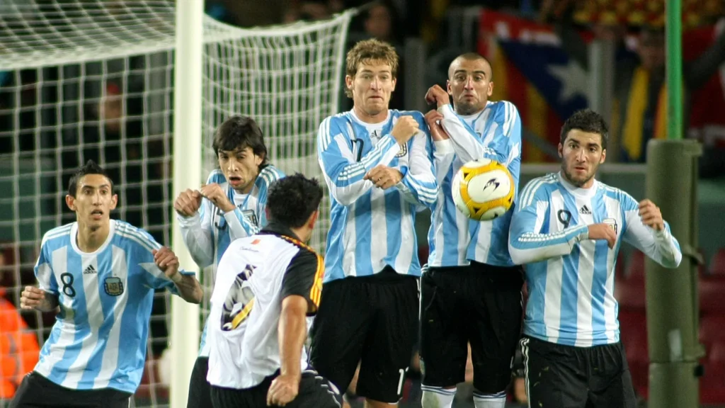 Argentina team is lining up to defend a free kick during a match.