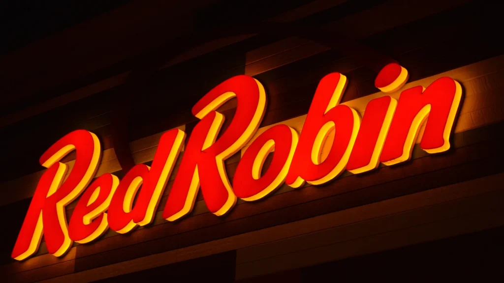 Neon-lit, red cursive signage for a Red Robin Gourmet Burgers and Brews restaurant