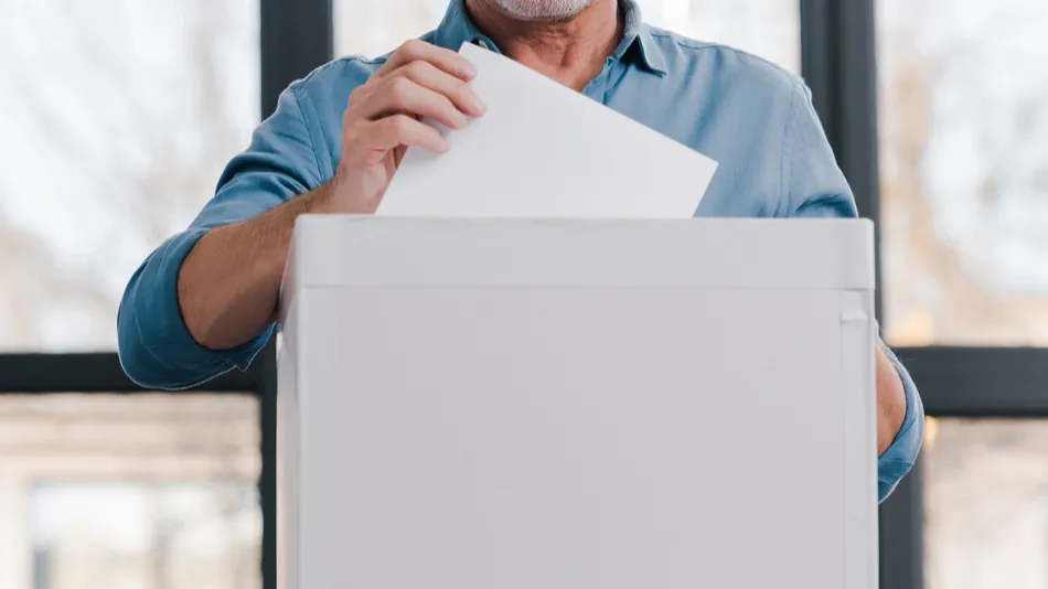 multicultural citizens putting ballots into voting boxes