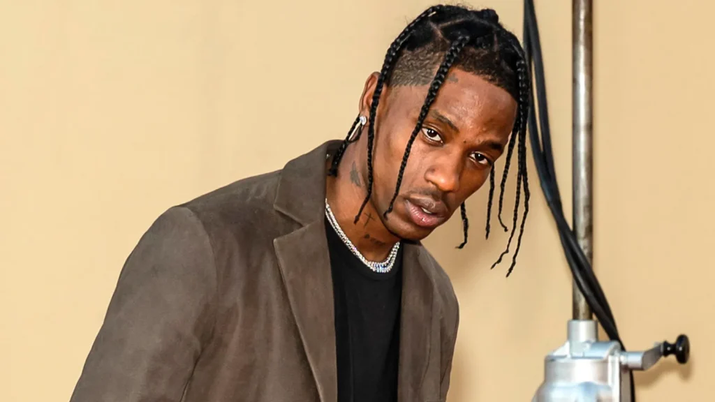 Travis Scott wearing a brown suede blazer over a black t-shirt