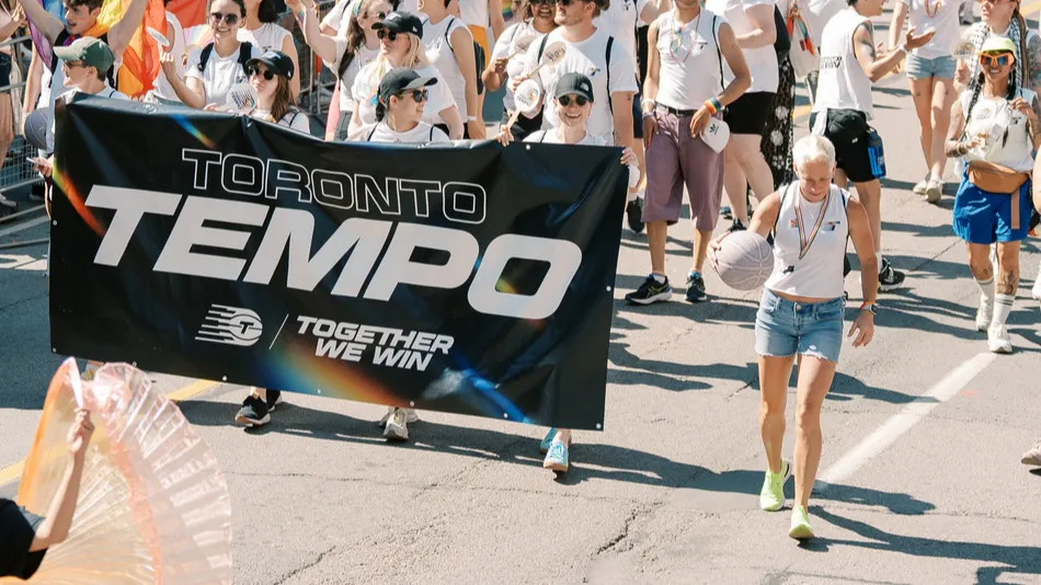 tempo group leading down sunlit avenue with banner and coordinated