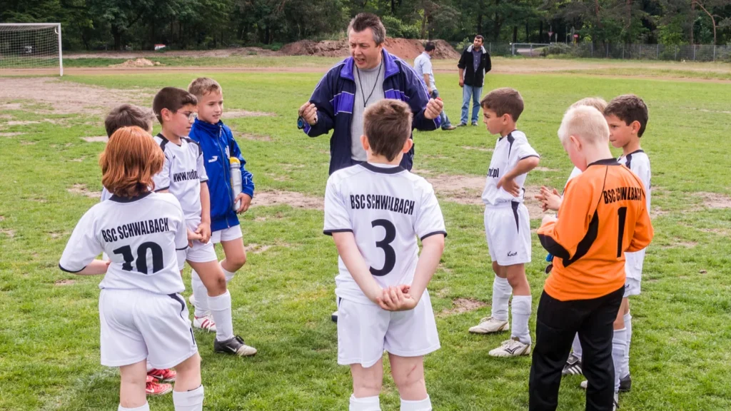 Trainer discusses the football match with the young players.