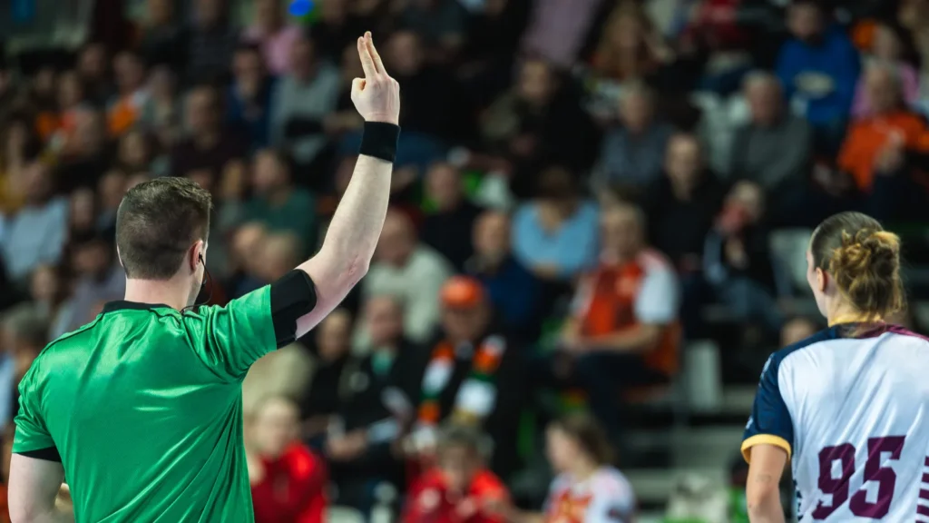 a handball referee showing a twominute suspension sign with fingers