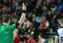 a handball referee showing a twominute suspension sign with fingers