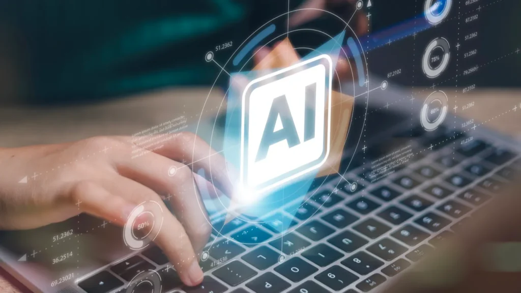 A glowing AI icon over a laptop keyboard, with digital data graphics and a person typing in the background.