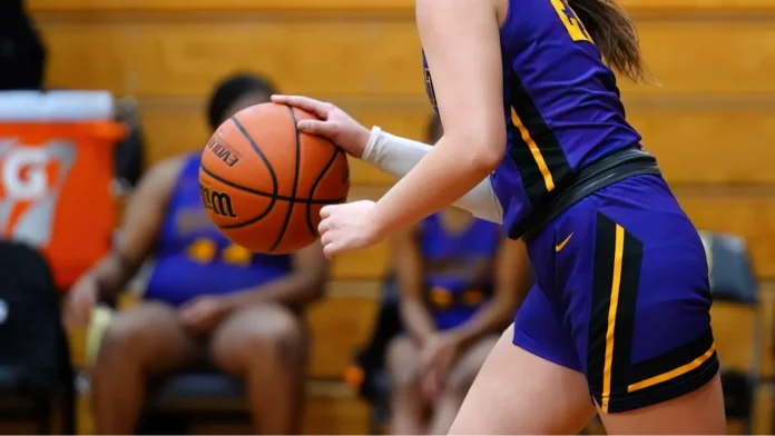 a young female player in a purple jersey on a