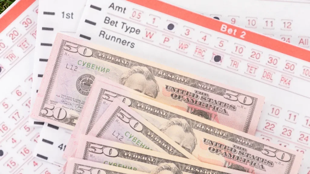 dollar banknotes and betting lists on green grass sports betting