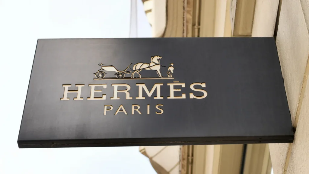 A black signboard featuring the logo for the French luxury brand Hermès