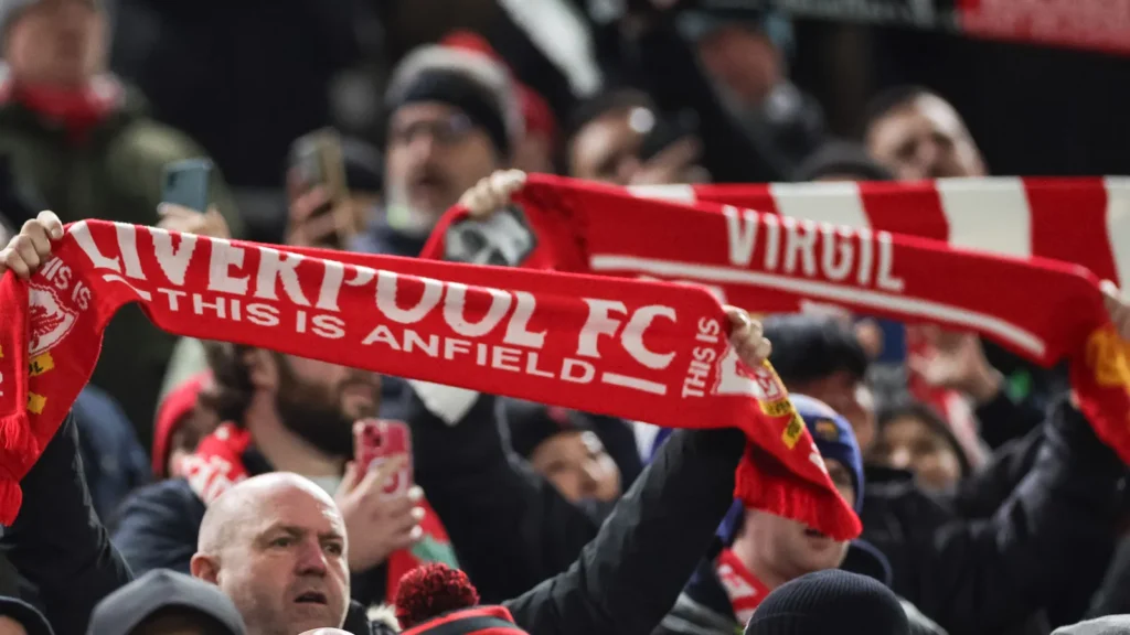 Liverpool fans hold scarfs up as they sing you'll never walk alone