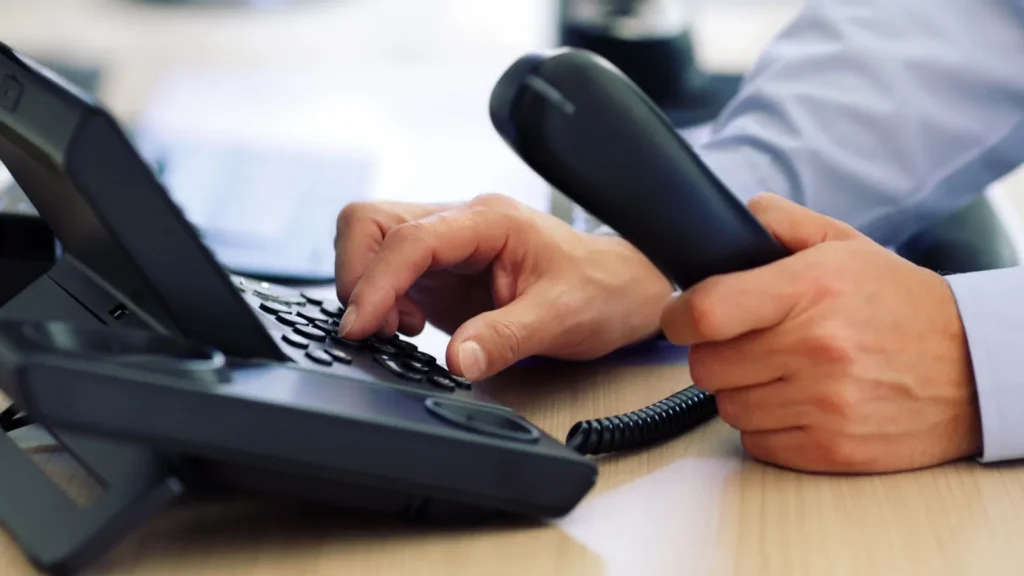 man dialing telephone keypad