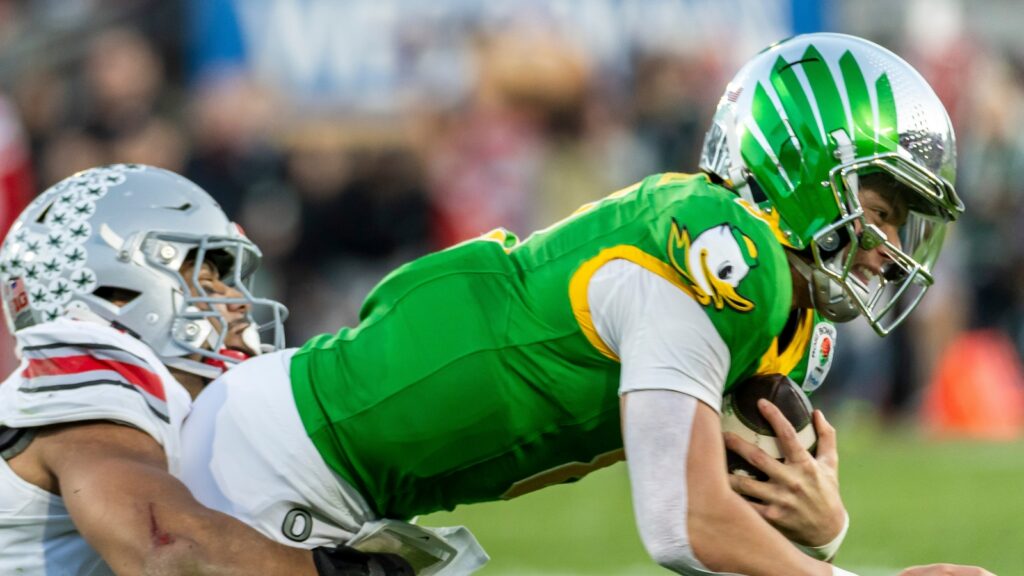 Oregon quarterback Dillon Gabriel #8 is brought down by Ohio State linebacker Cody Simon #0 during the 2025 Rose Bowl game.