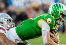 Oregon quarterback Dillon Gabriel #8 is brought down by Ohio State linebacker Cody Simon #0 during the 2025 Rose Bowl game.