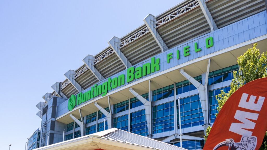 Huntington Bank Field stadium exterior with a large green sign against a blue sky.