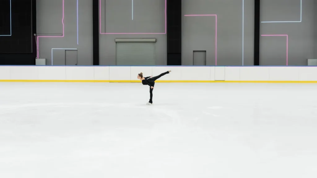 side view of figure skater in black bodysuit skating in