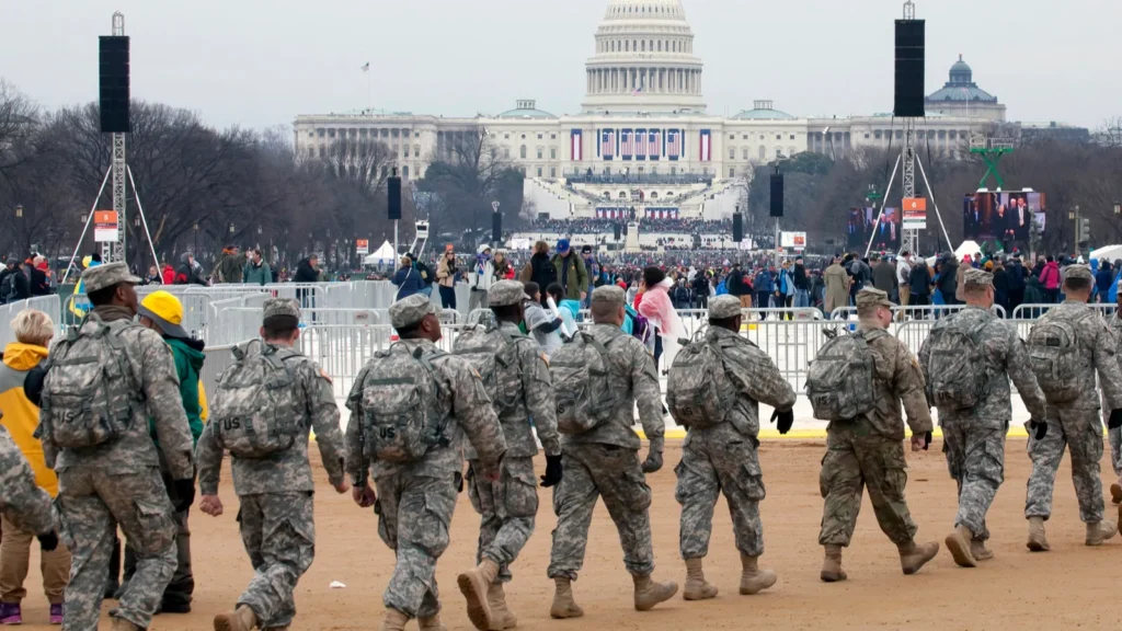 Soldiers walk in front of the Capitol building.