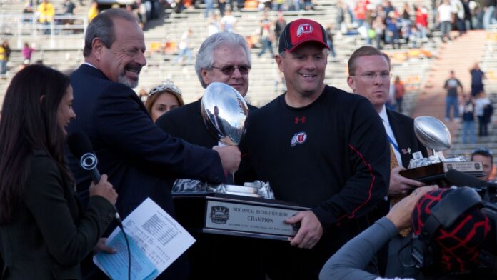 EL PASO – DECEMBER 31: Oscar Leeser presents the Sun Bowl Trophy to Kyle Whittingham of UTAH for their overtime 30 to 27 win over Georgia Tech at the Sun Bowl on December 31, 2011 in El Paso, Texas.