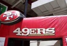 An inflatable red archway featuring the San Francisco 49ers logo and "49ERS" text outside a stadium facility.