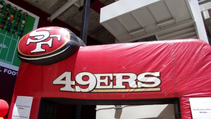 Inflatable San Francisco 49ers entrance at Fan Day at Candlestick Park. An inflatable red archway featuring the San Francisco 49ers logo and "49ERS" text outside a stadium facility.