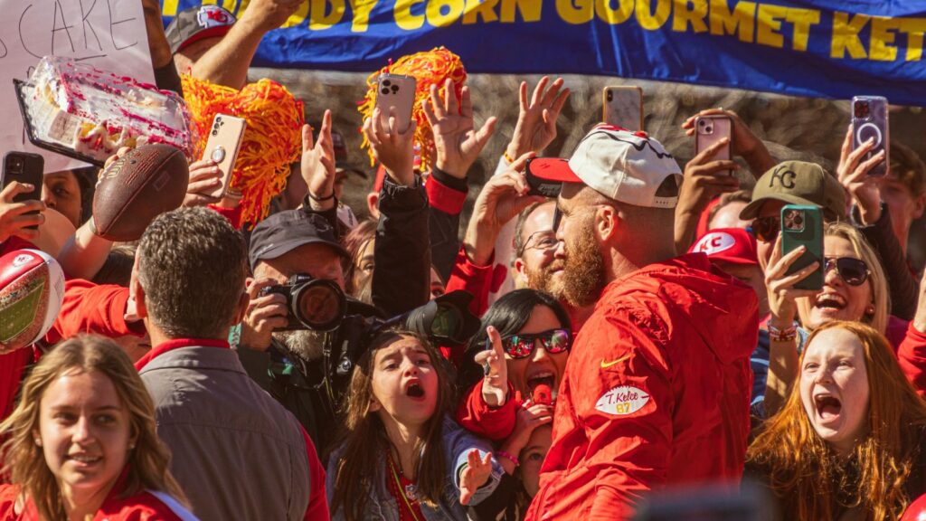 Travis Kelce, who plays the tight end position for the Kansas City Chiefs NFL football team interacts with many fans during the Super Bowl LVIII Parade