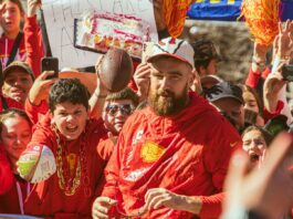 Travis Kelce interacting with many fans during the Super Bowl LVIII Parade.