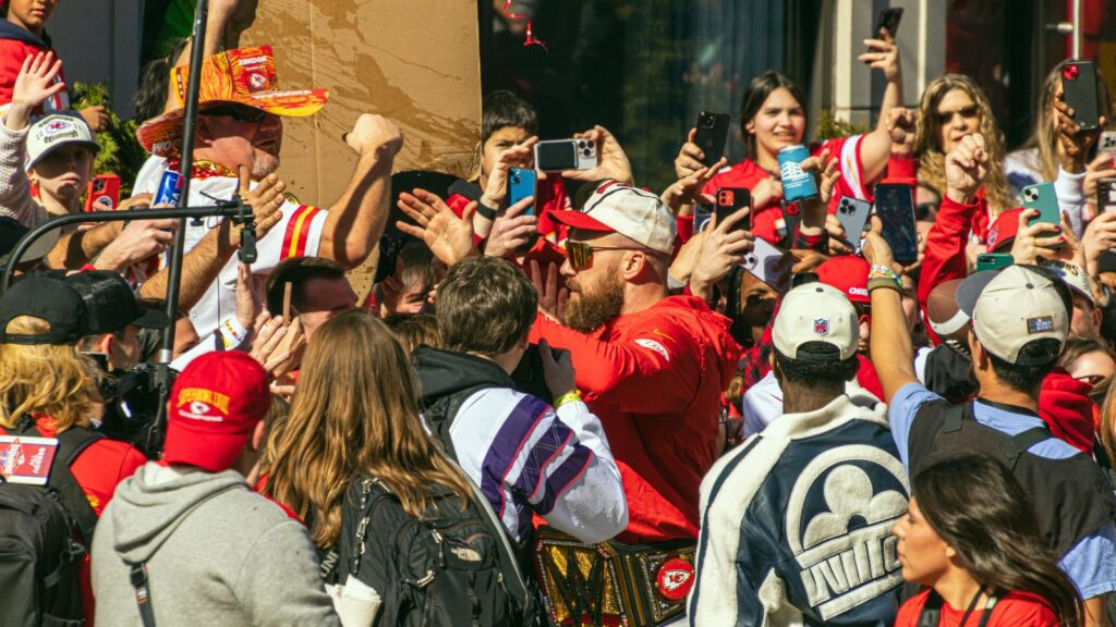Travis Kelce, who plays the tight end position for the Kansas City Chiefs NFL football team interacts with many fans during the Super Bowl LVIII Parade