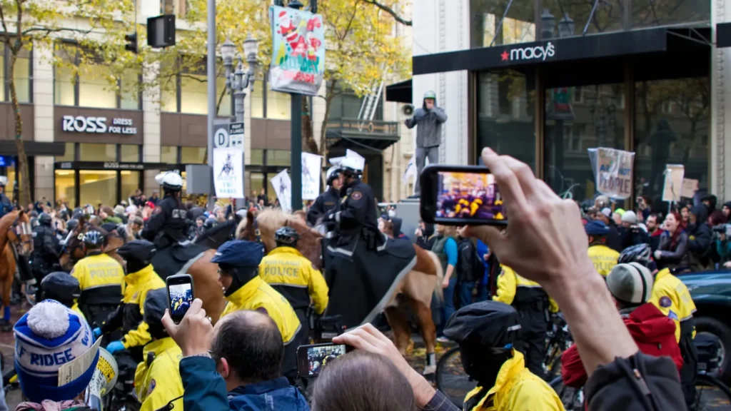 Spectators use their phones to record a protest.