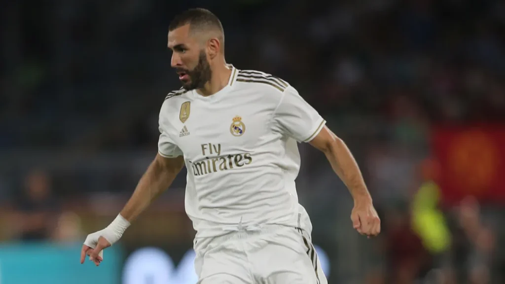 AS Roma and Real Madrid players competing during a friendly football match.
