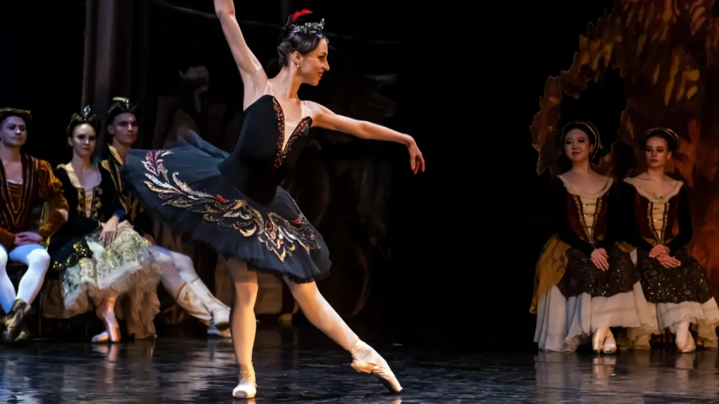 classical ballerina performing on stage in a black tutu