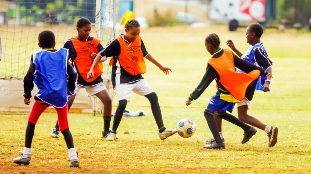 A group of children playing soccer at school.