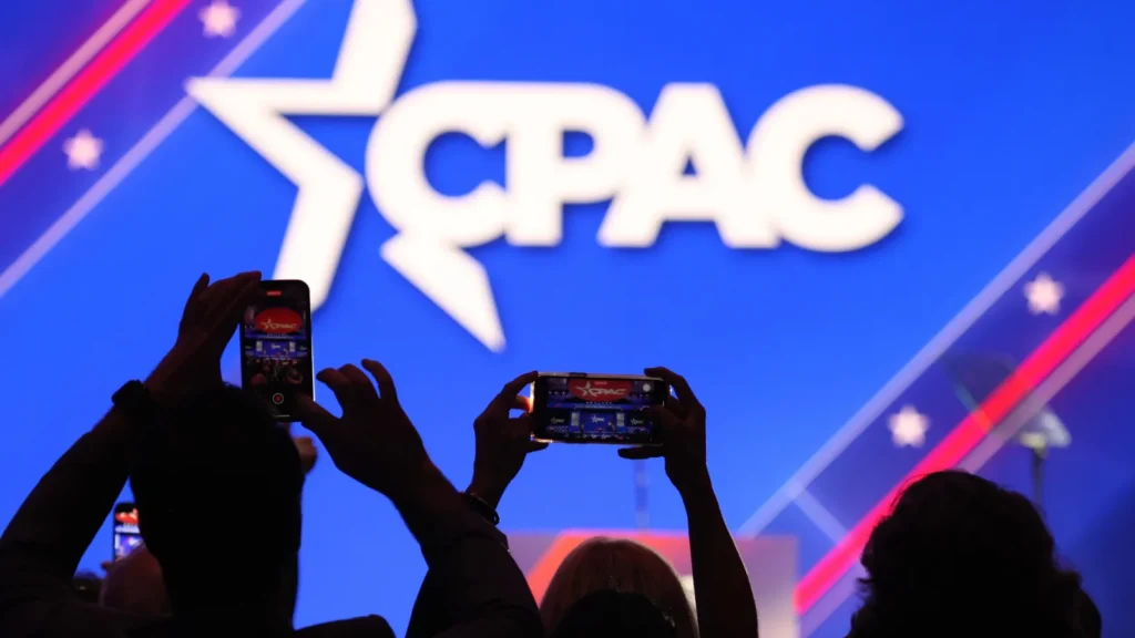 Audience members filming at a CPAC event.