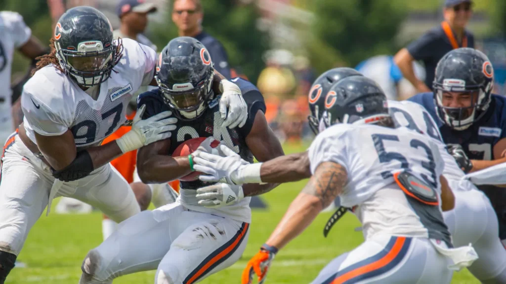 Chicago Bears running back carrying the ball during a practice session.