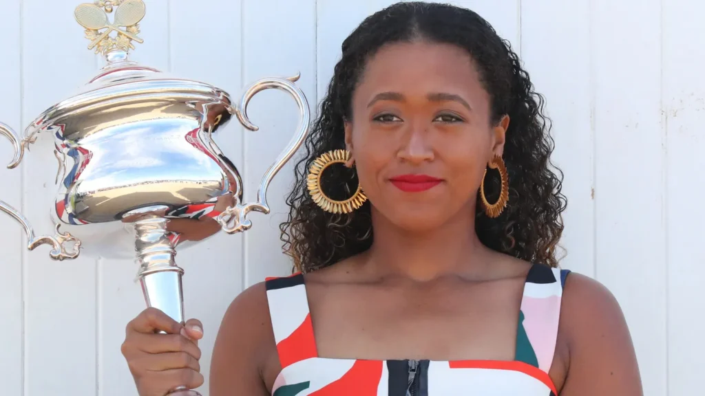 Naomi Osaka celebrating her victory with her trophy