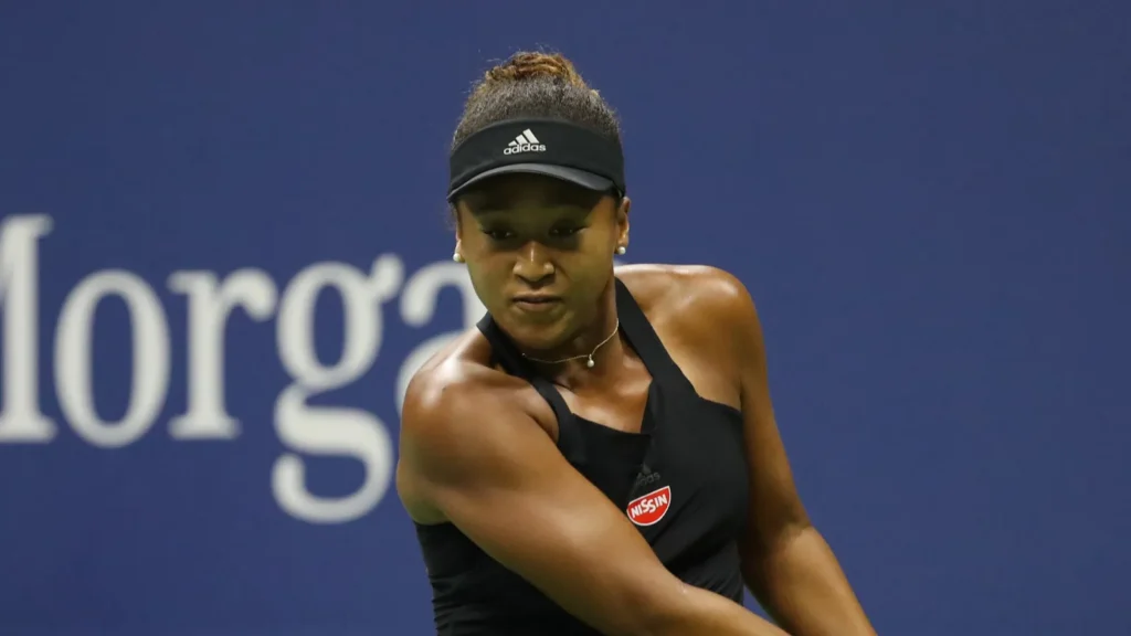 Naomi Osaka playing tennis in court.
