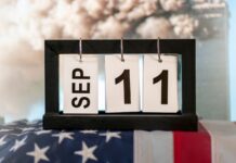 A calendar display set to September 11 resting on an American flag, symbolizing Patriot Day and the remembrance of the September 11, 2001 terrorist attacks.