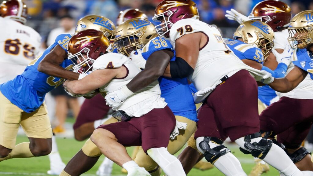 College football player Cam Skattebo tackle an opponent during a game.