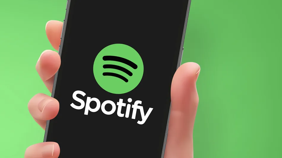 Woman hand holding the smartphone with Spotify logo