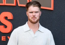 Sam Darnold hit triggers explosive sideline incident in 49ers-Seahawks clash NFL quarterback Sam Darnold posing in a light polo shirt in front of an event backdrop.