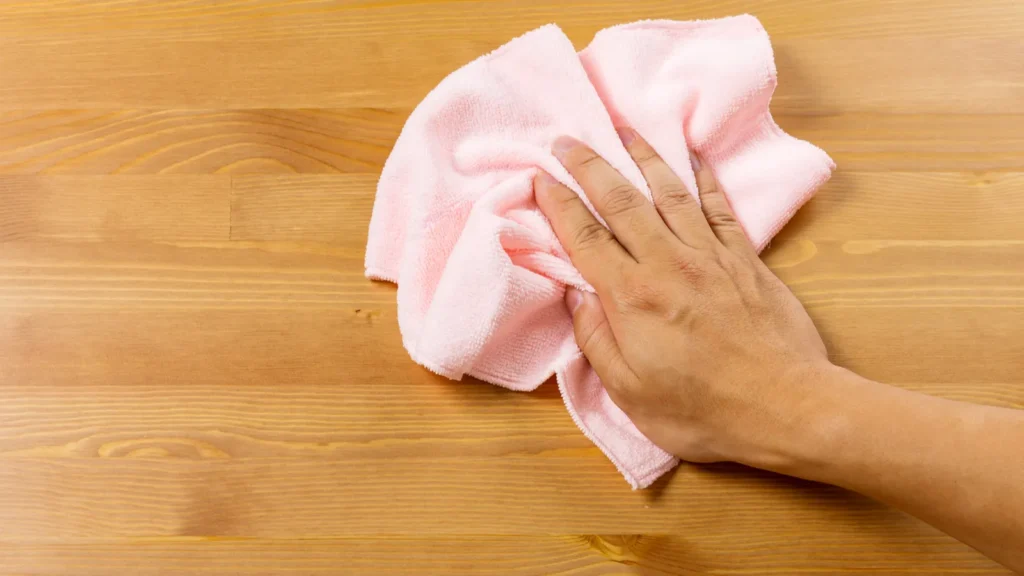 cleaning table by pink rag