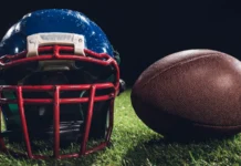 Kyle Whittingham faces questions over key Iowa game decision closeup shot of american football helmet with ball on green