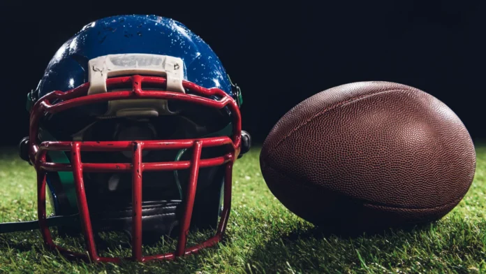 closeup shot of american football helmet with ball on green