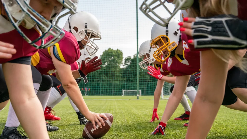 photo of athletes women wearing white helmets playing american football