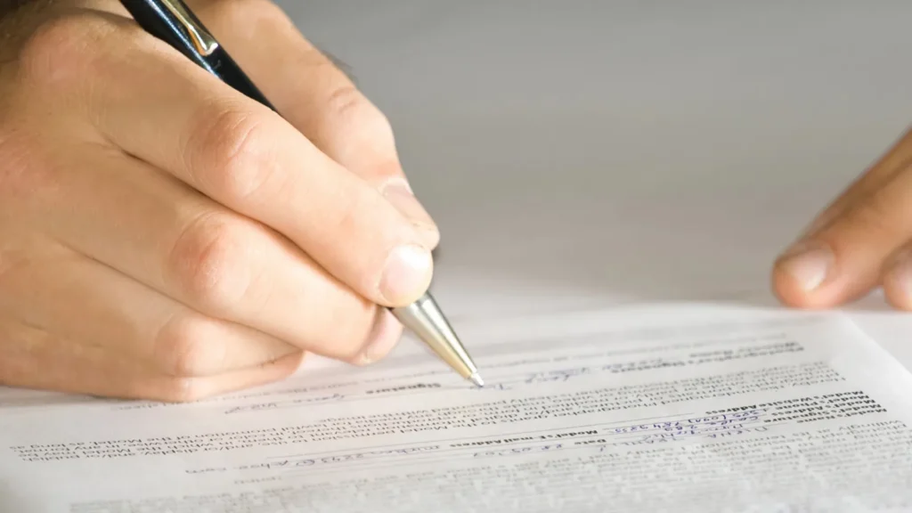 A person singing the contract with a pen.